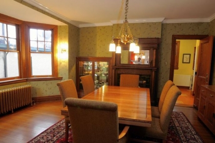 In the dining room, the radiator was sandblasted and repainted to shows off its detail. The moss-colored wallpaper depicting birds was chosen because of its historic pattern. Restoring the oak-trimmed sashes of the bay windows almost made David Lagnese give up on the project.