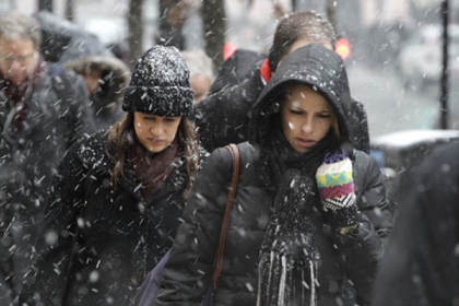 Commuters brace the snow as they arrive in downtown Chicago this morning. The Windy City was expecting as much as 10 inches of snow from a storm that will head toward western Pennsylvania tonight.