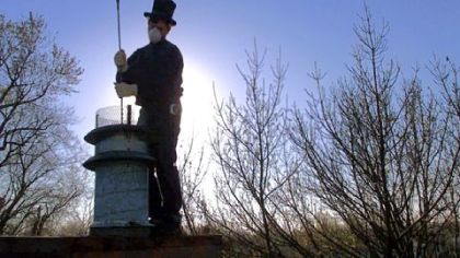 Chimney sweep Arlen Clure, of Moline, Ill., pushes a wire brush down a chimney in Bettendorf, Iowa.