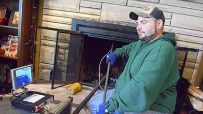 Chris Rankin, a senior tech from Advanced Chimney Sweeps, uses a camera to inspect a chimney at the house of Jeff Klysz in Indiana Township.