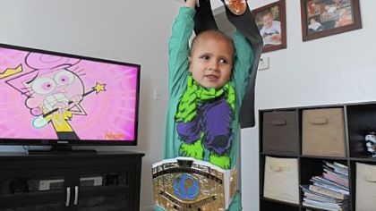 Connor Michalek, 7, shows off his wrestling belts at his Hampton home. Wrestling is an "everyday, all day activity," for him and his brother, Jackson, according to their mother, Brittany Caligiuri.