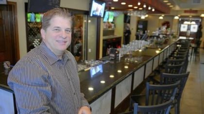 Owner Michael Roman of Roman Bistro in Forest Hills stands at the front bar.