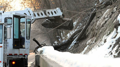 A Pittsburgh Public Works crew removes the debris from a landslide from behind the barrier along the McArdle Roadway early Thursday morning. The slide, in the same location as a slide two weeks ago, did not reach the roadway but filled the gap behind the barrier. The road was closed for the debris removal.